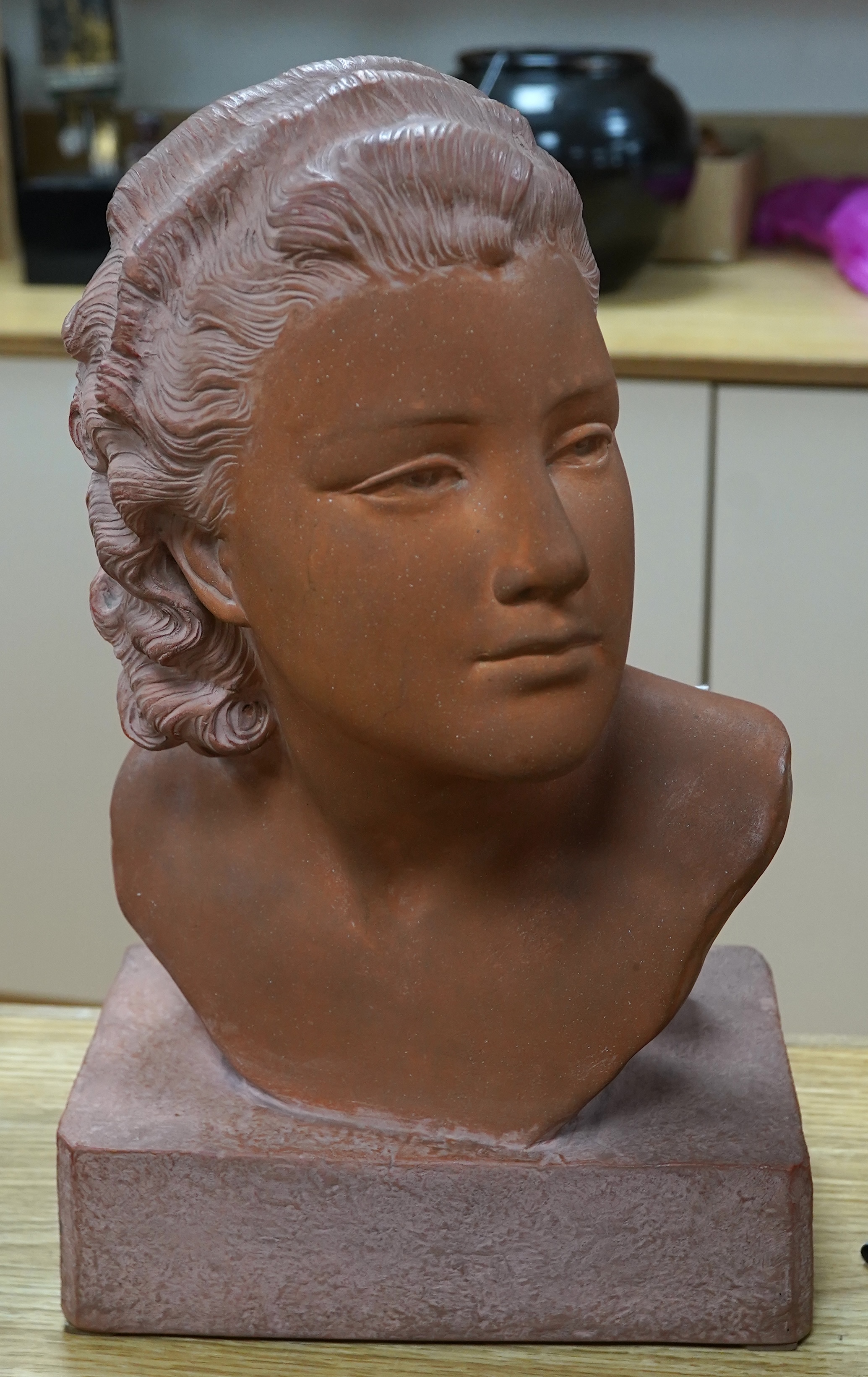 A terracotta bust of a young woman, signed U Cipriani, 37cm high. Condition - good